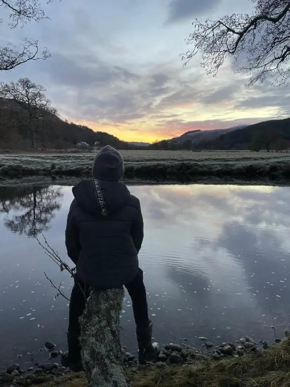 a person sitting in front of a body of water at The Cnoc Hotel in Beauly