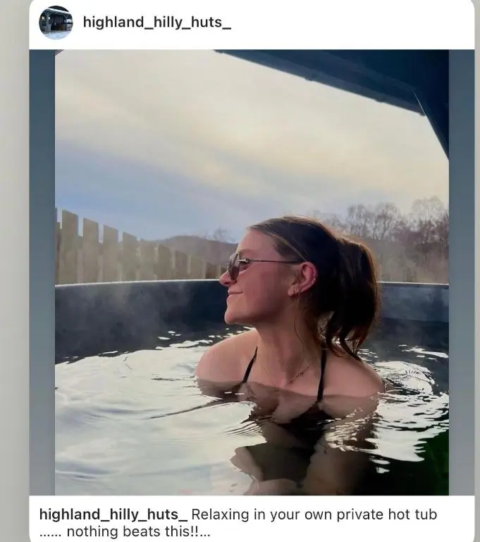 a woman in the water in a bath tub at Highland cabin - relaxing hot tub in Inverness