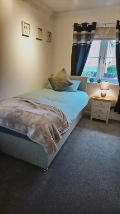 a bedroom with a bed and a window at Three bedroom house in Culloden, Inverness in Culloden