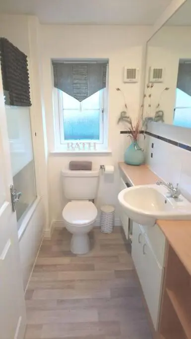 a bathroom with a toilet and a sink and a window at Three bedroom house in Culloden, Inverness in Culloden