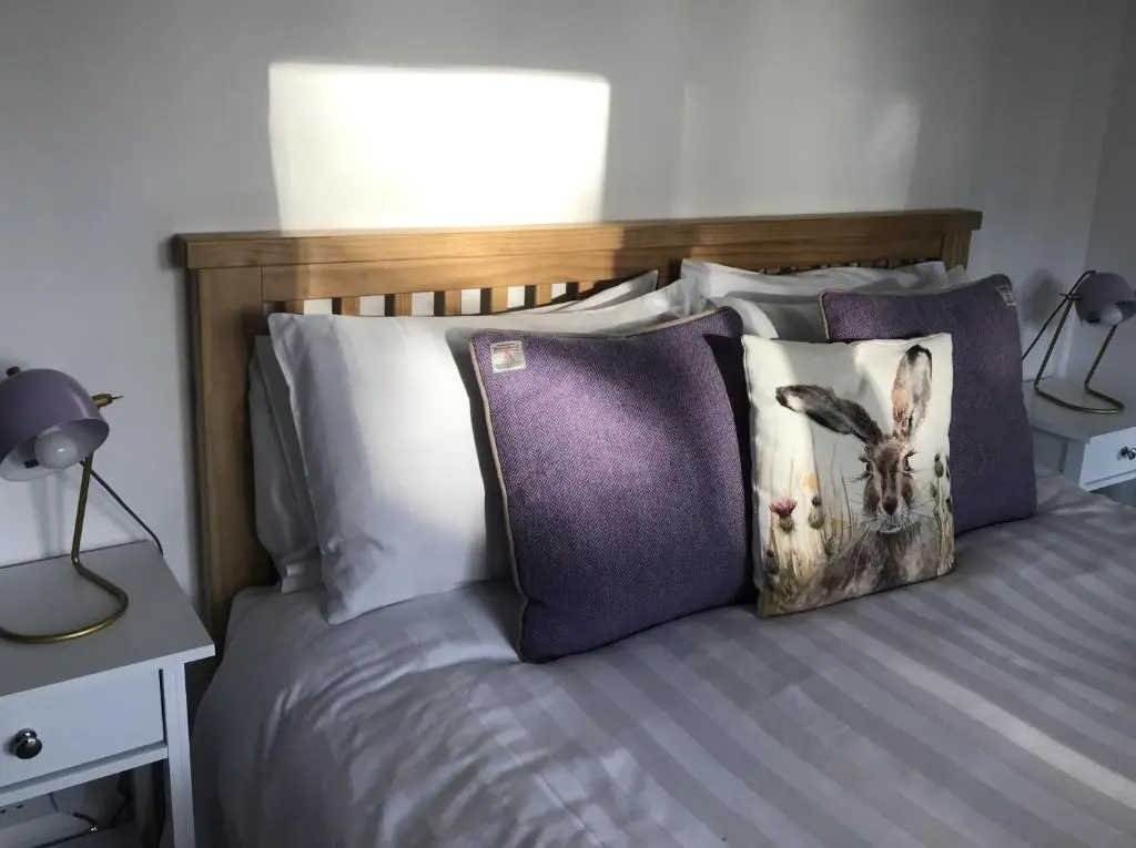 a bed with a wooden headboard and pillows on it at No. 9 in Inverness