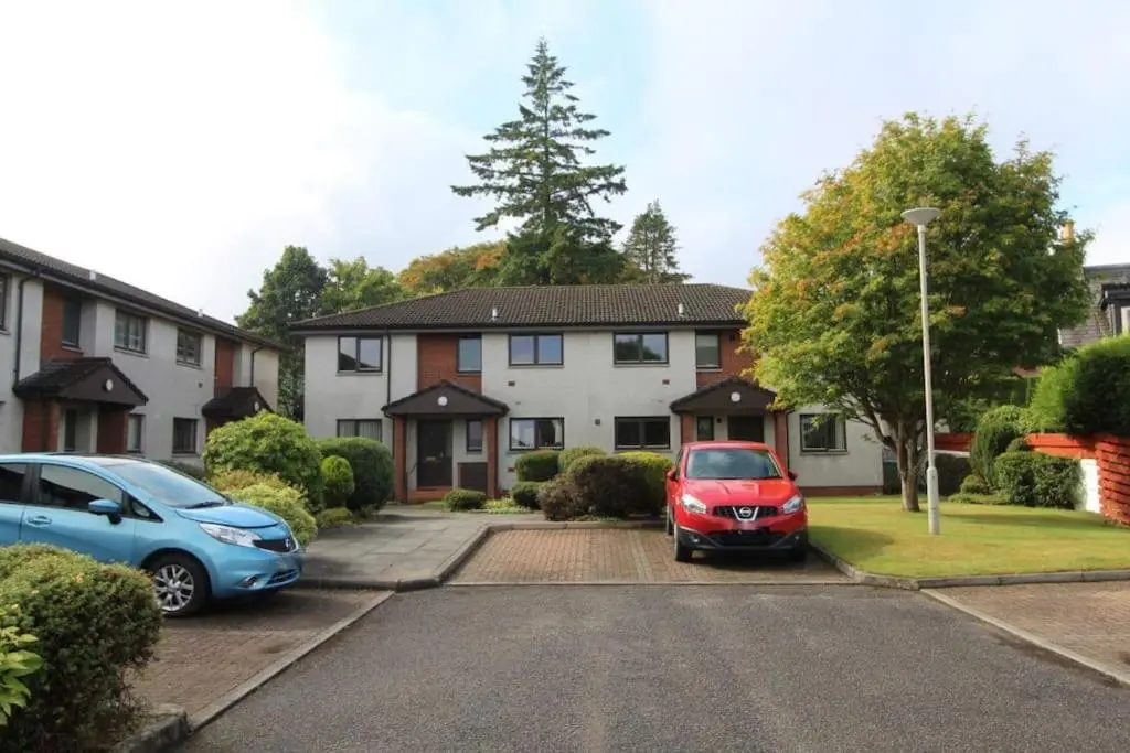 two cars parked in a parking lot in front of a house at No. 9 in Inverness