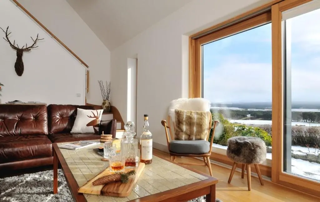 a living room with a couch and a table at Tom's Lodge in Boat of Garten