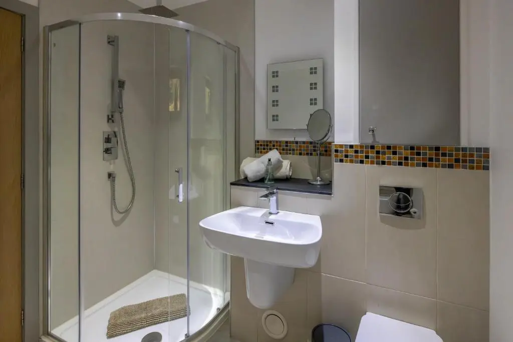 a bathroom with a glass shower and a sink at Tom's Lodge in Boat of Garten