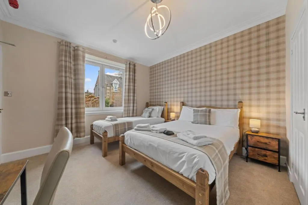 a bedroom with two beds and a window at mySTAYINN Strathblane 7 Bedroom Full House - Inverness in Inverness