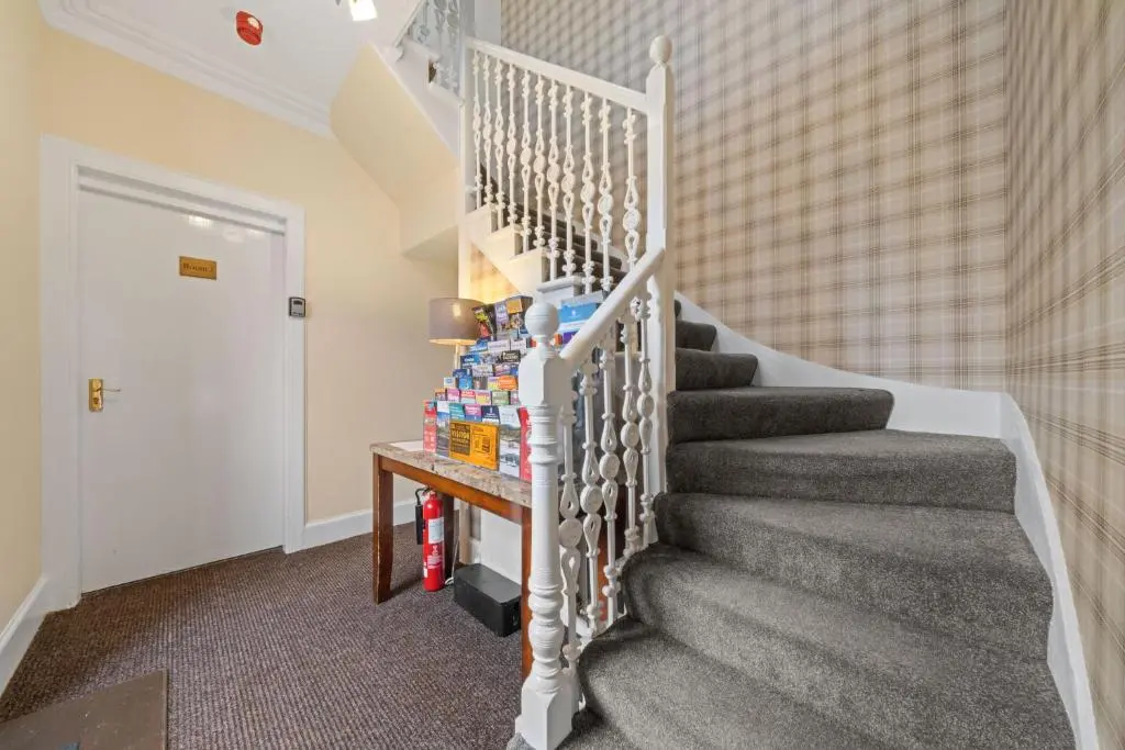 a staircase in a home with a stair case at mySTAYINN Strathblane 7 Bedroom Full House - Inverness in Inverness