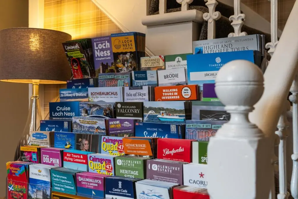 a pile of books stacked on top of each other at mySTAYINN Strathblane 7 Bedroom Full House - Inverness in Inverness