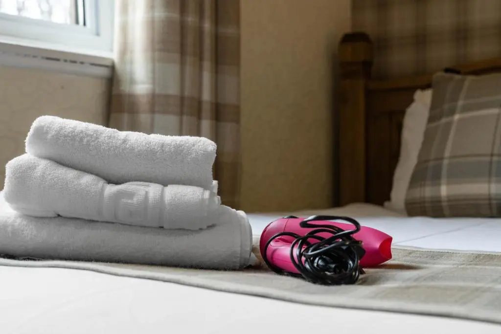 a pile of towels sitting on a bed at mySTAYINN Strathblane 7 Bedroom Full House - Inverness in Inverness