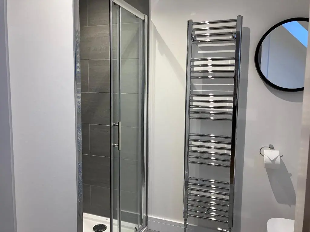 a glass shower in a bathroom with a mirror at Berryfield Holiday Apartment in Inverness