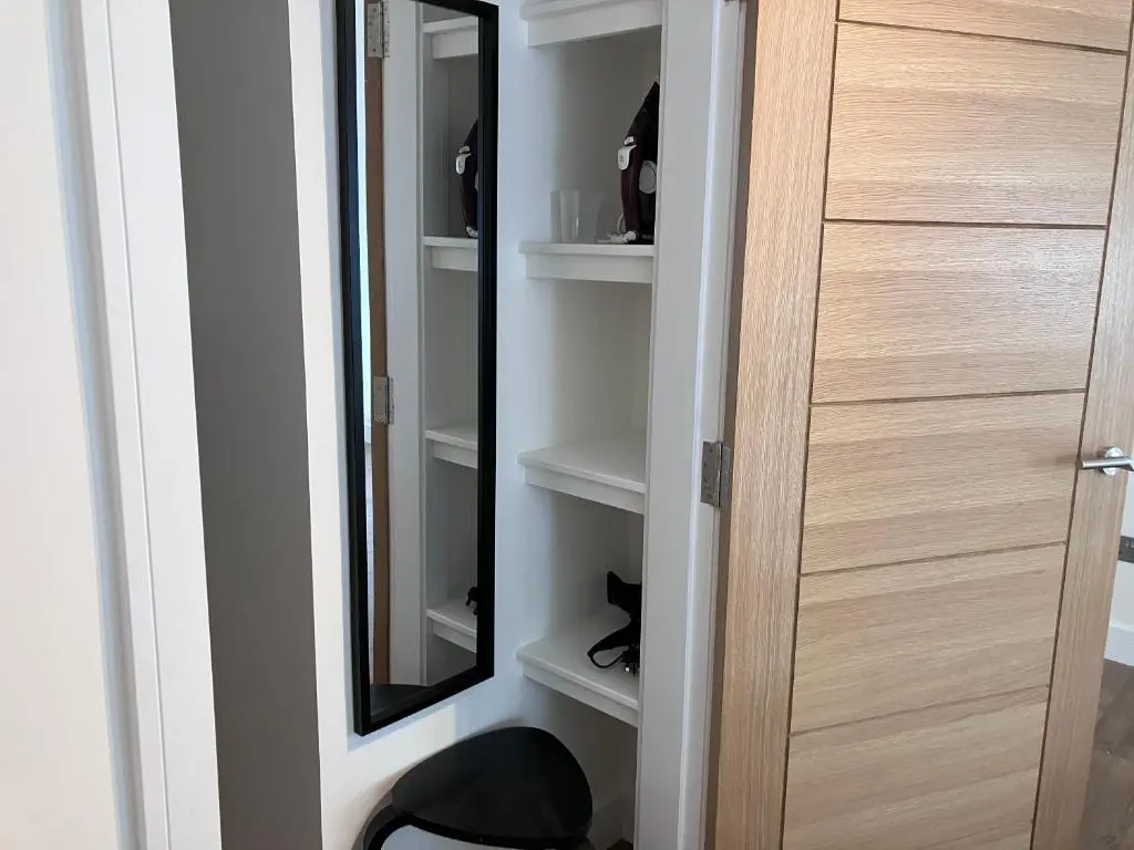 a closet with a mirror next to a door at Berryfield Holiday Apartment in Inverness