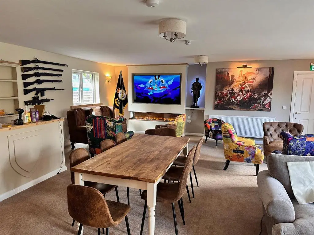 a living room with a wooden table and chairs at Forces Manor in Kincraig
