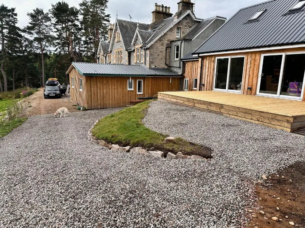 a house with a dog on a gravel driveway at Forces Manor in Kincraig