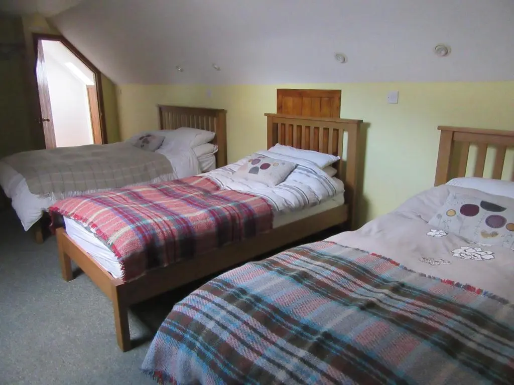 a bedroom with two beds at Kestrel, Longhouse Cottages in Rosemarkie