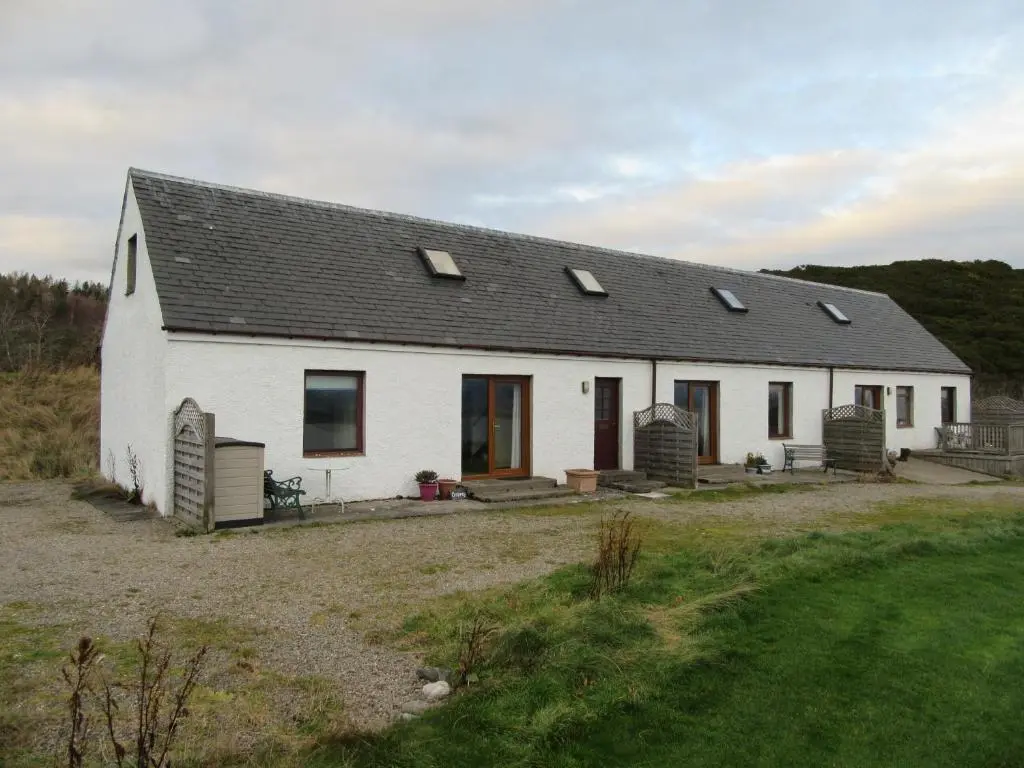 a white house with a black roof at Kestrel, Longhouse Cottages in Rosemarkie
