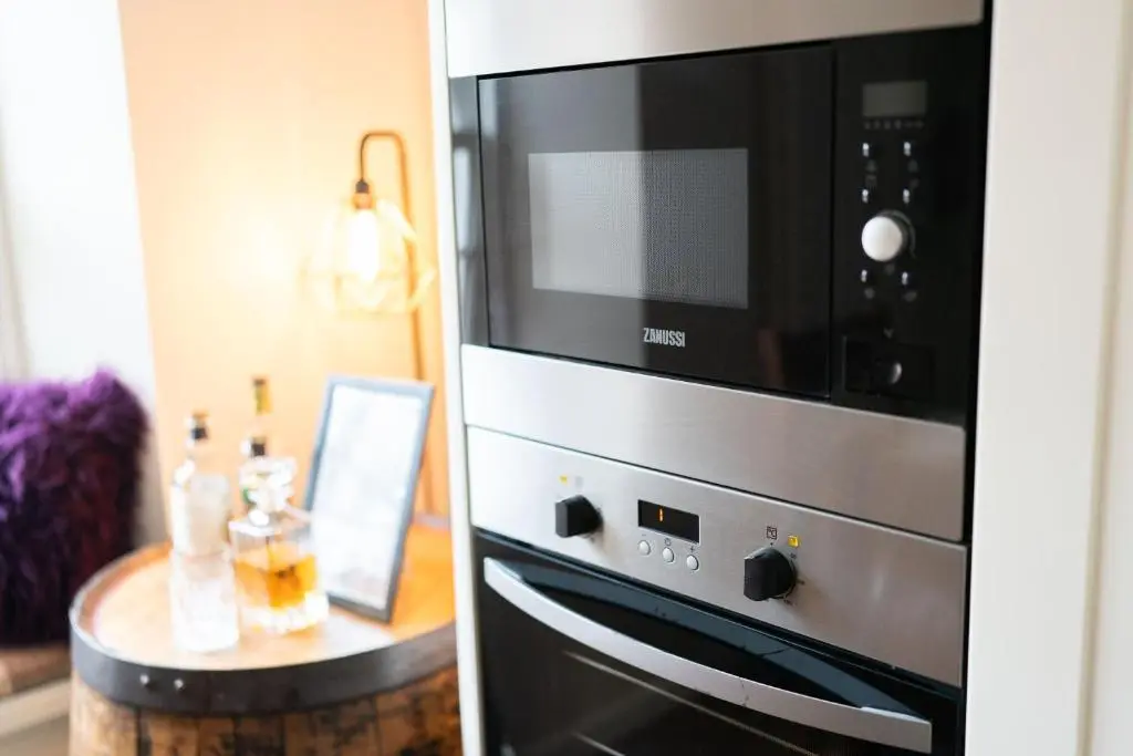 a kitchen with a microwave oven and a table at Ranch House Cottage, Pet Friendly Stay, Inverurie in Thainstone