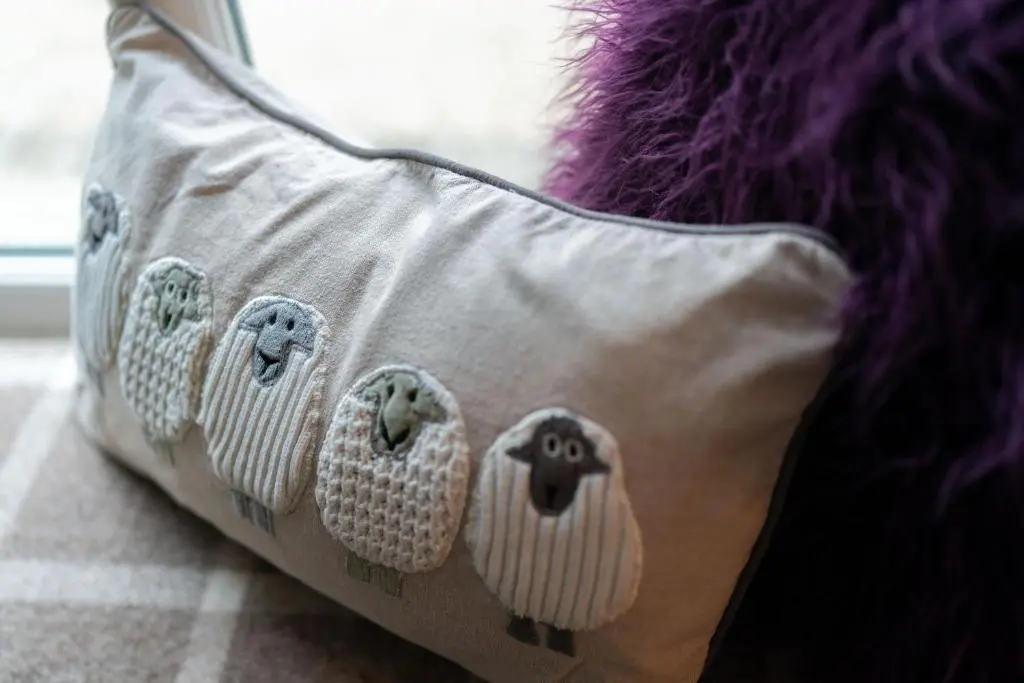a pillow with sheep on it sitting on the floor at Ranch House Cottage, Pet Friendly Stay, Inverurie in Thainstone