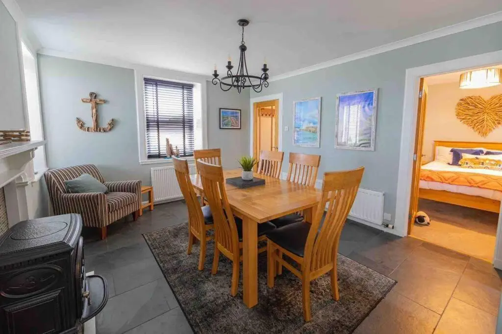 a dining room with a table and chairs and a bedroom at Hill Crest - Clifftop Escape with Sea View in Cullen