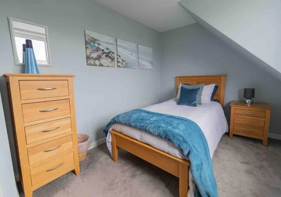 a bedroom with a bed and a dresser with a blue blanket at Hill Crest - Clifftop Escape with Sea View in Cullen