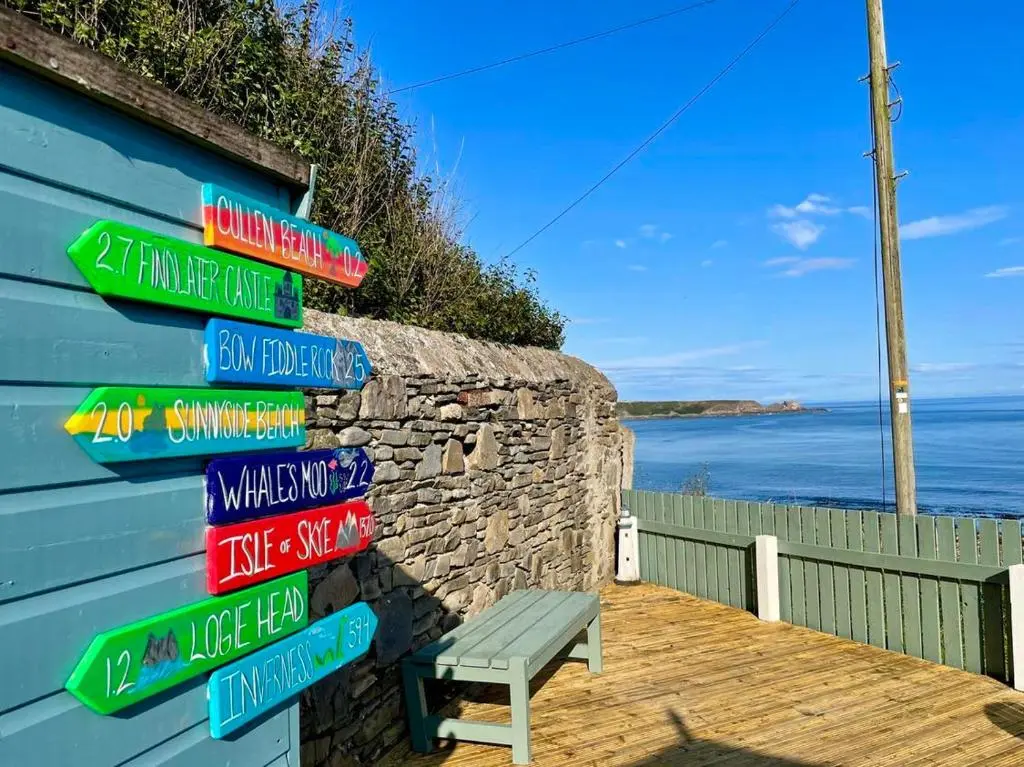 a bunch of street signs on the side of a building at Hill Crest - Clifftop Escape with Sea View in Cullen