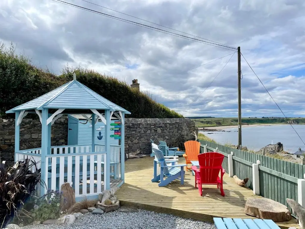a wooden deck with chairs and a gazebo at Hill Crest - Clifftop Escape with Sea View in Cullen