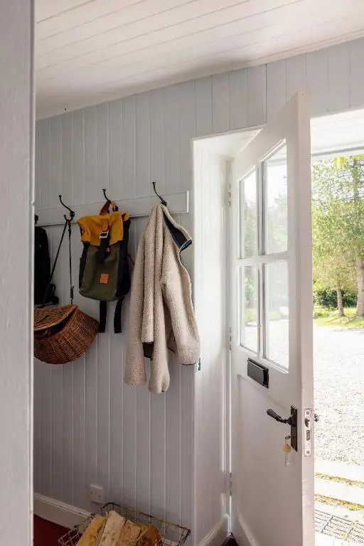 a hallway with a door with towels on the wall at Cuttieshillock in Banchory