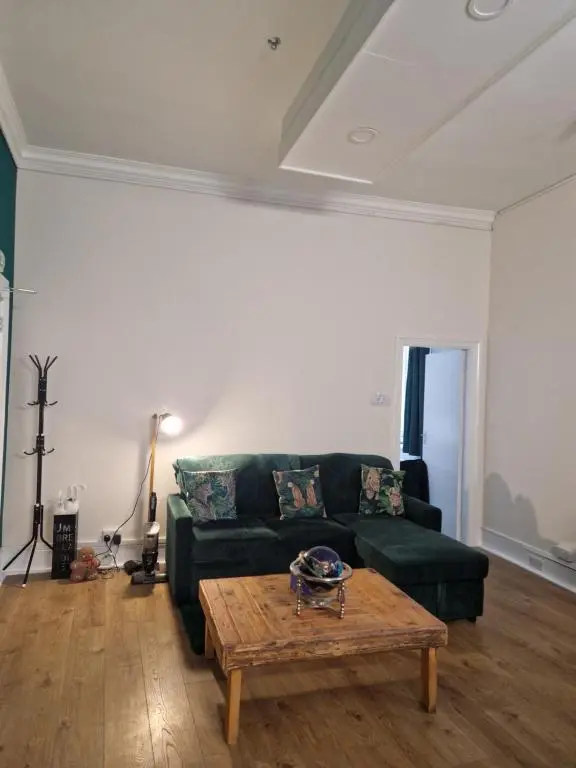 a living room with a green couch and a coffee table at Baile Apartment Central Inverness in Inverness