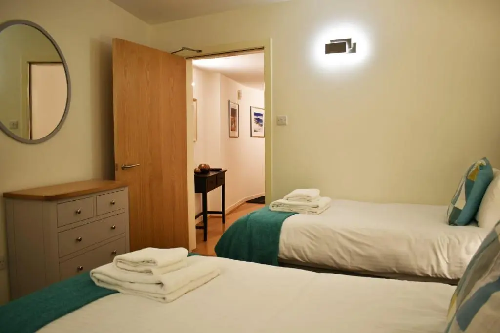 a bedroom with two beds and a mirror and a dresser at Cannon Point BW7 in Fort Augustus