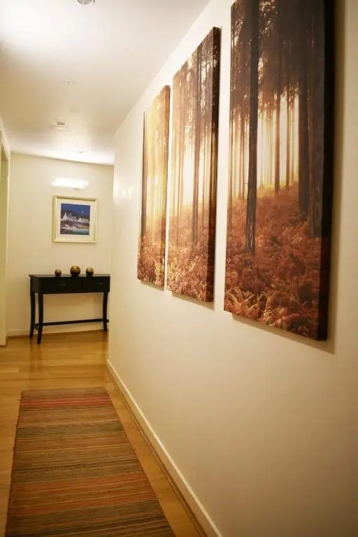 a hallway with four paintings on a wall at Cannon Point BW7 in Fort Augustus