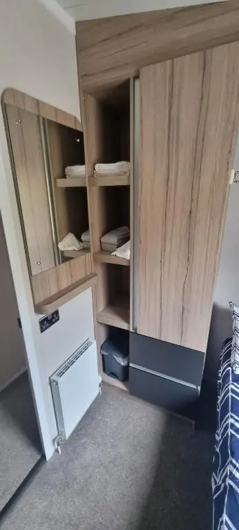 a room with a wooden cabinet with a door at Lynton lodges in Evanton