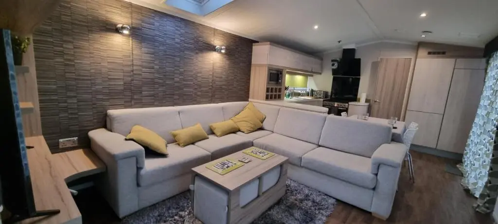 a living room with a white couch and yellow pillows at Lynton lodges in Evanton