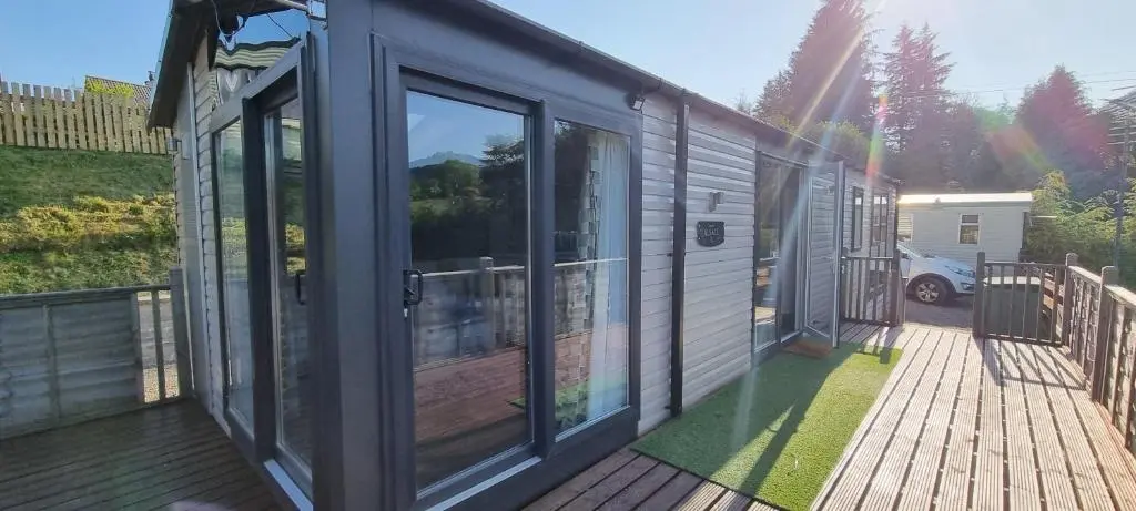 a house with sliding glass doors on a deck at Lynton lodges in Evanton