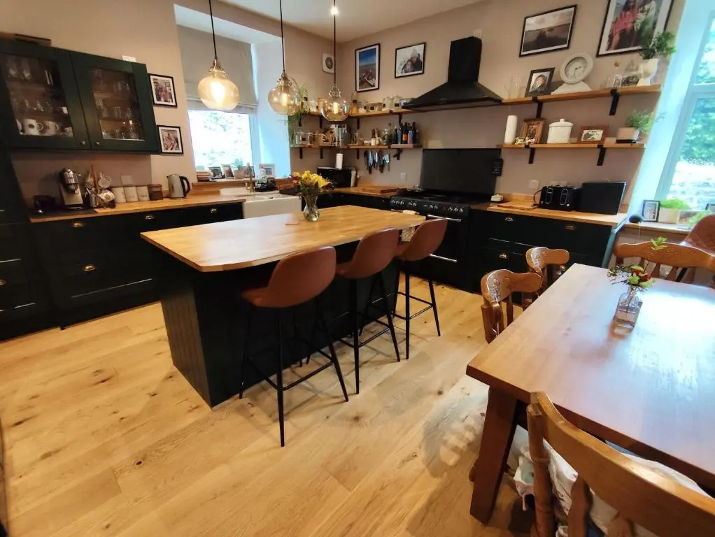 a kitchen with a wooden island with a wooden table at Abbeyfield B&B in Dufftown