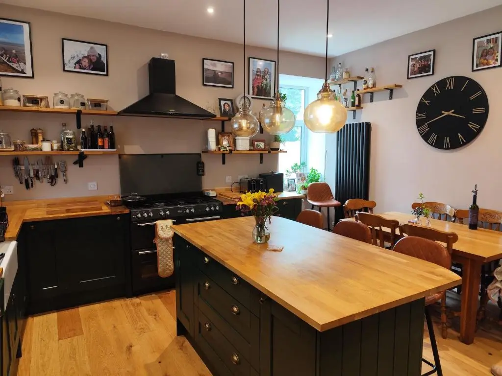 a kitchen with a table and a clock on the wall at Abbeyfield B&B in Dufftown