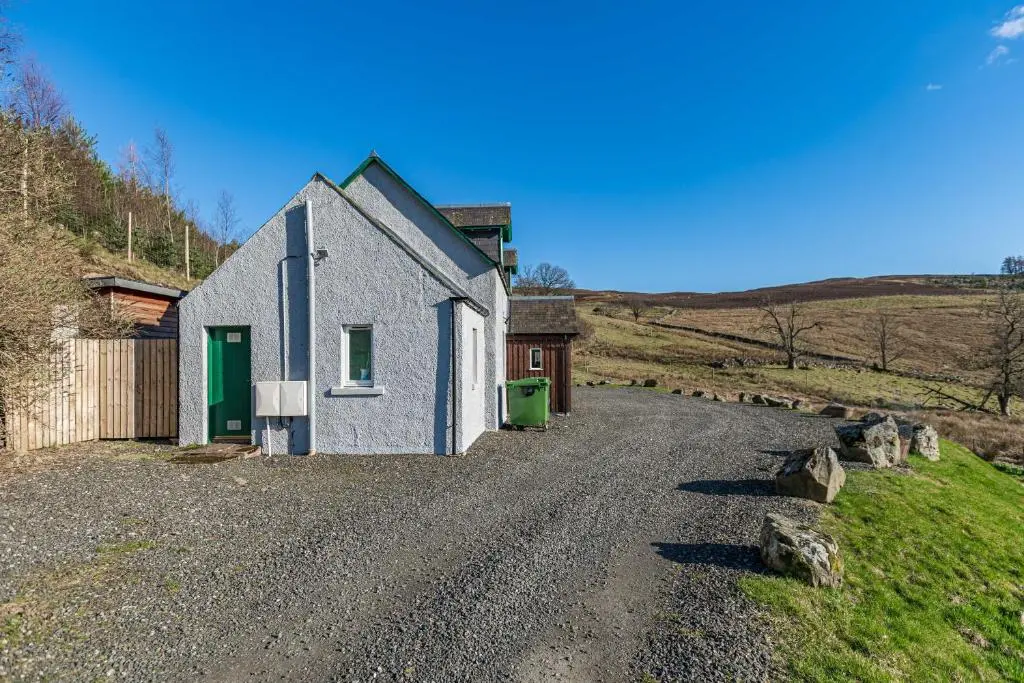 a small house on a gravel road in a field at Stags View with Hot Tub in Blairgowrie