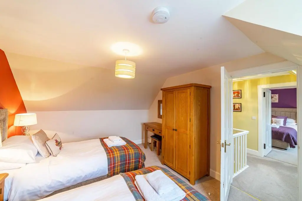 a bedroom with two beds and a desk at Stags View with Hot Tub in Blairgowrie