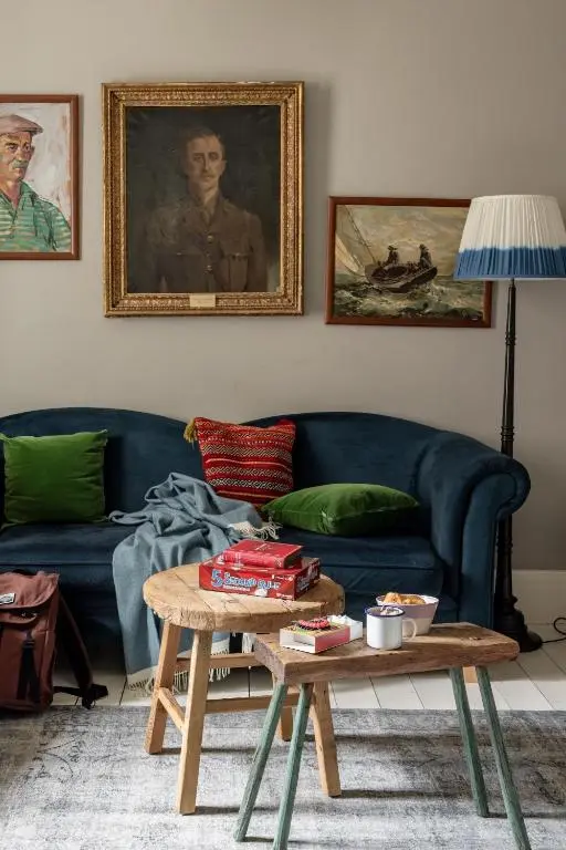 a living room with a blue couch and a table at North Lodge & River Cabin in Banchory