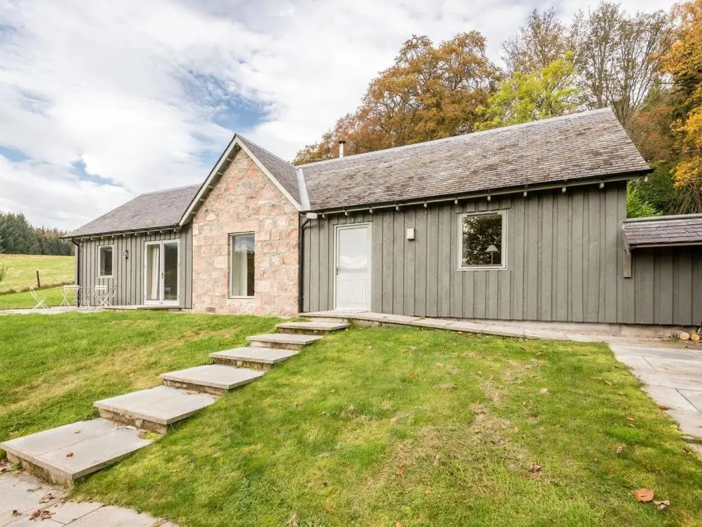 a stone house with a yard and a building at The Kennels in Ballogie