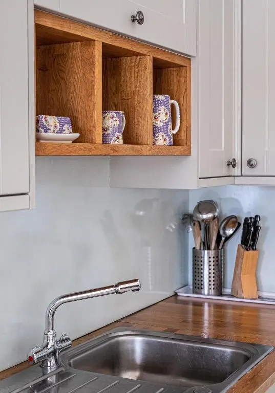 a kitchen with white cabinets and a sink at The Kennels in Ballogie