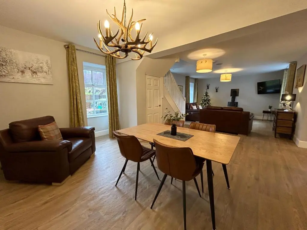 a living room with a table and a couch at The Stables with Hot Tub in Cray