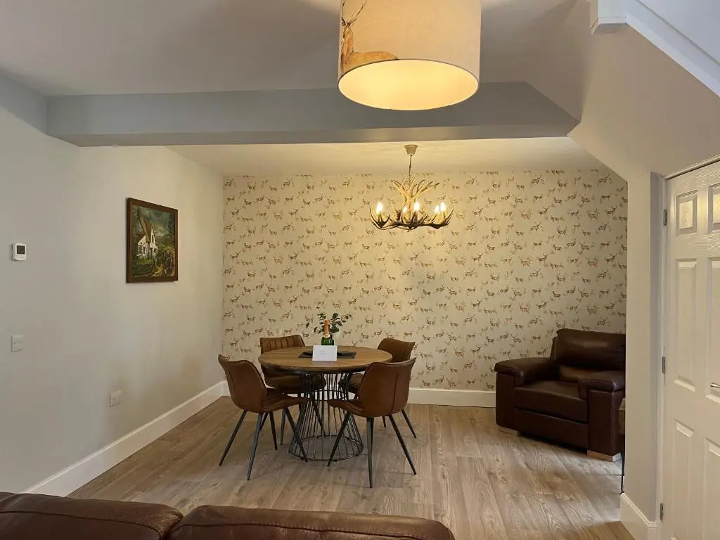 a living room with a table and chairs and a couch at The Stables with Hot Tub in Cray