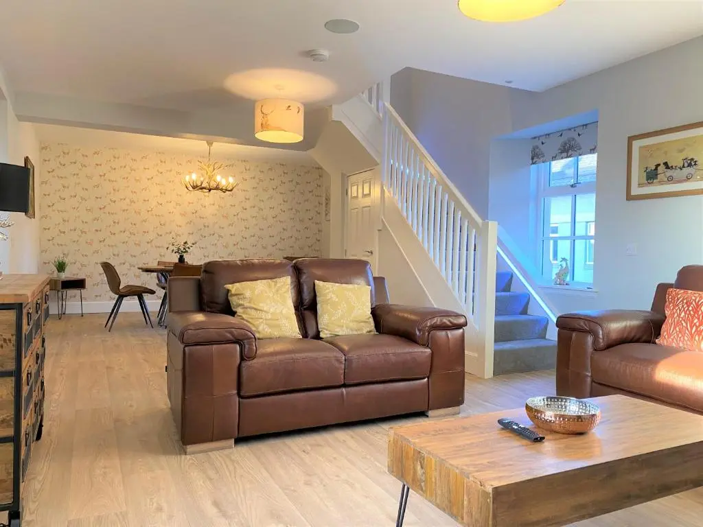 a living room with a couch and a table at The Stables with Hot Tub in Cray