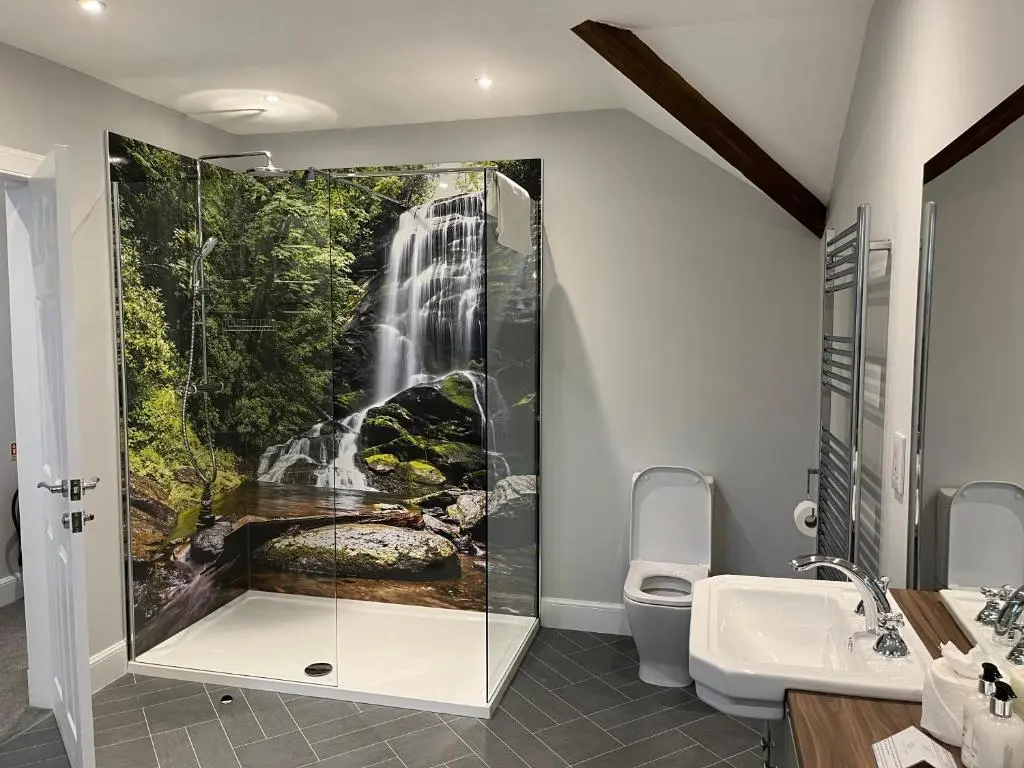 a bathroom with a waterfall painting on the wall at The Stables with Hot Tub in Cray