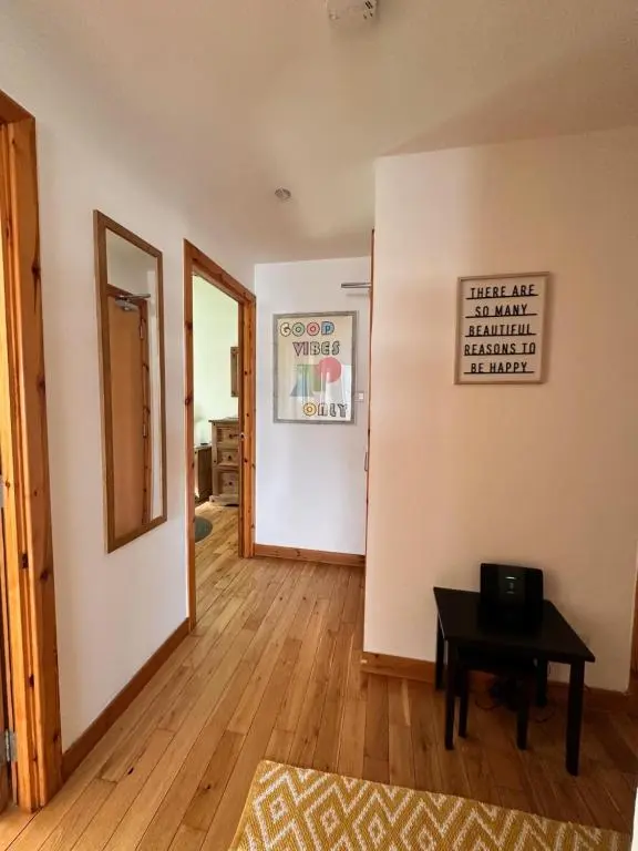 a living room with a table and a hallway at City centre apartment next to Bus and Train Station in Inverness