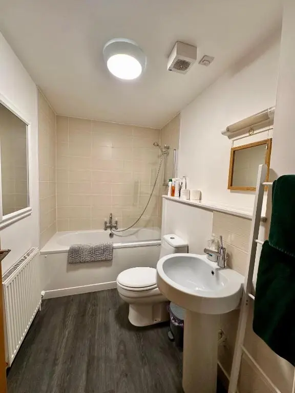 a bathroom with a toilet and a sink and a tub at City centre apartment next to Bus and Train Station in Inverness