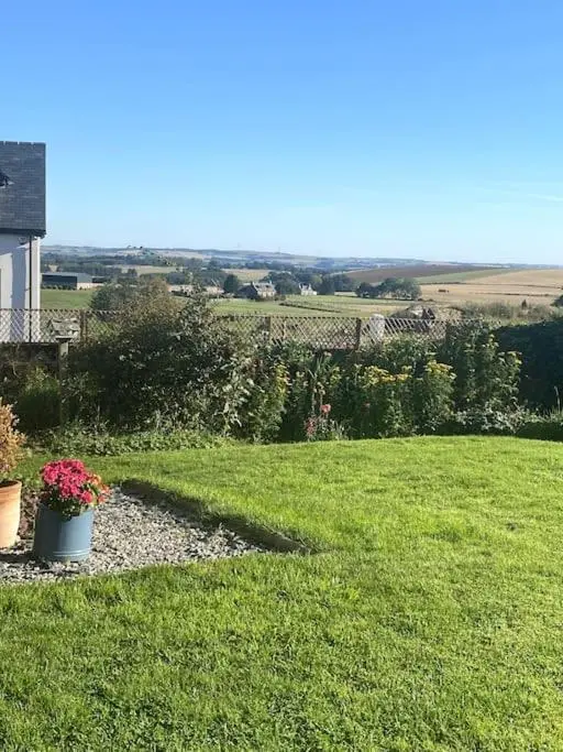 a view of a yard with flowers in a field at Cosy and modern 1 bedroom garden house - very dog friendly! in Tarves