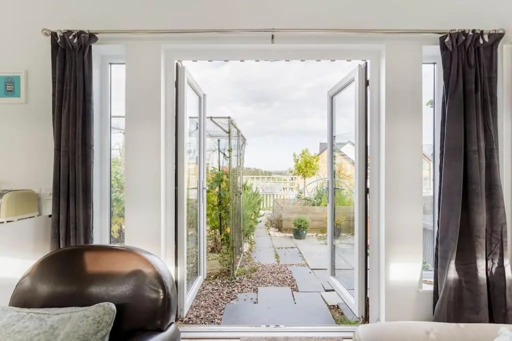 a room with a sliding glass door to a garden at Cosy and modern 1 bedroom garden house - very dog friendly! in Tarves