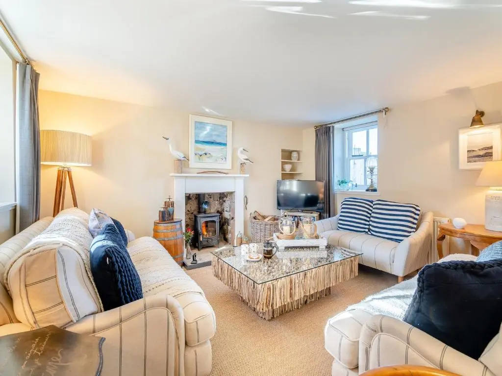 a living room with two couches and a fireplace at The Old Net Shed in Whitehills