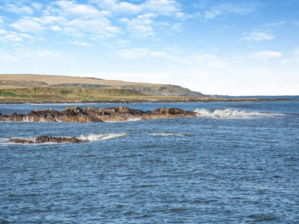 a large body of water with rocks in it at The Old Net Shed in Whitehills