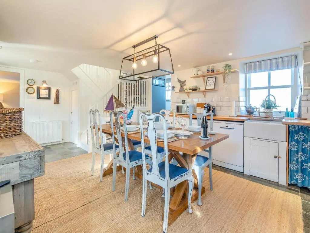 a kitchen and dining room with a table and chairs at The Old Net Shed in Whitehills