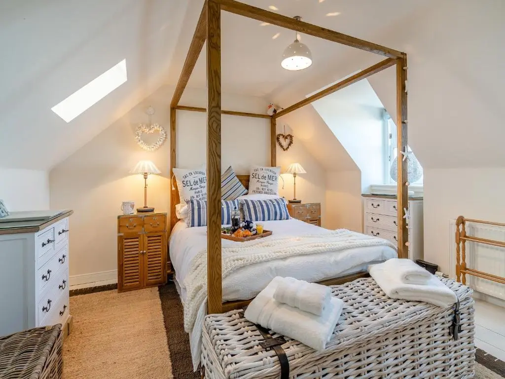 a bedroom with a canopy bed with a wooden frame at The Old Net Shed in Whitehills
